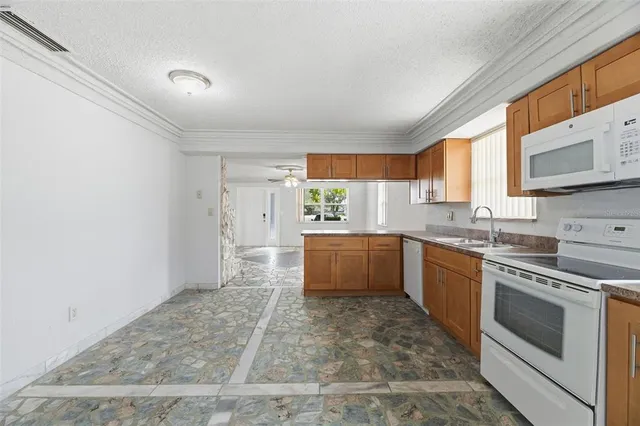 a kitchen with stainless steel appliances granite countertop a stove a sink and a refrigerator