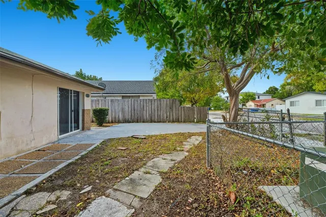 a view of a backyard with a large tree and wooden fence