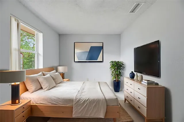 a bedroom with a bed and a flat screen tv