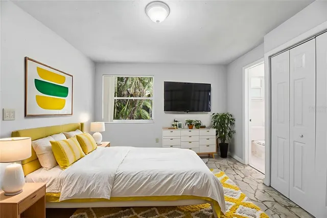 a bedroom with a bed and a flat screen tv