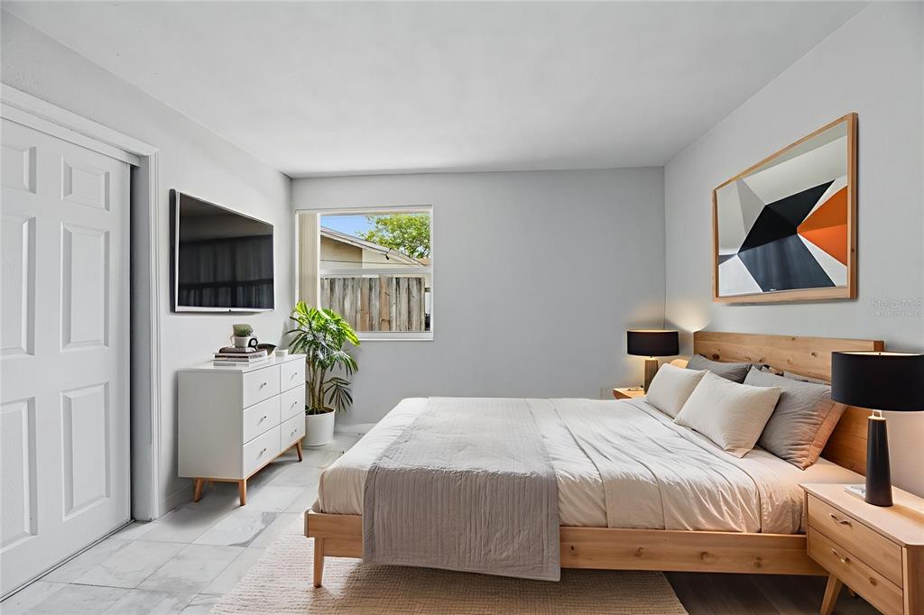 5735 Hayes Street Hollywood, FL 33021 - Photo 10 of 40 a bedroom with a bed a couch and a flat screen tv