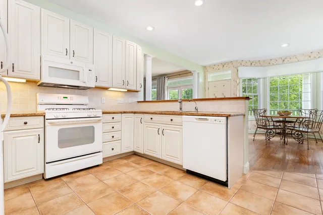a living room with stainless steel appliances kitchen island granite countertop furniture and a view of kitchen