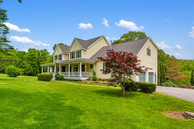 a front view of a house with a garden and plants