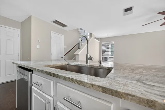 a kitchen with kitchen island a sink and a stove