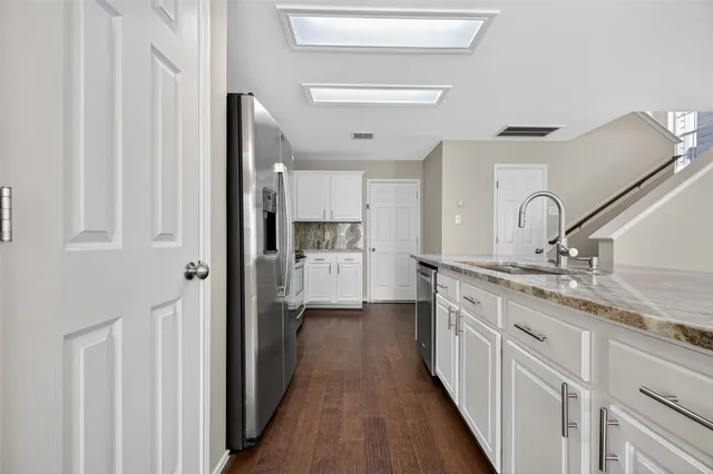 a kitchen with stainless steel appliances granite countertop a refrigerator and a sink