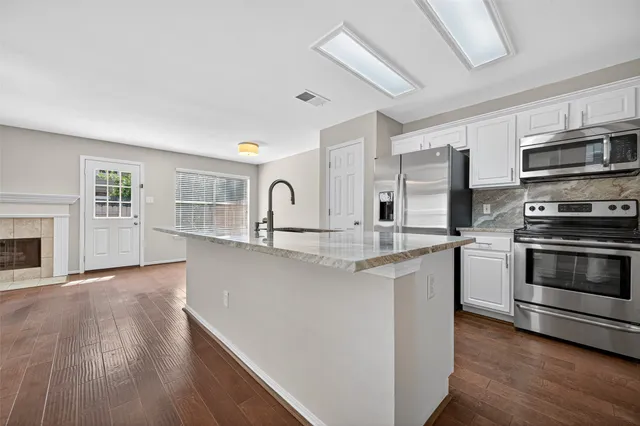 a kitchen with stainless steel appliances a stove sink and microwave