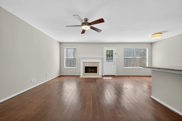 a view of empty room with wooden floor and fireplace