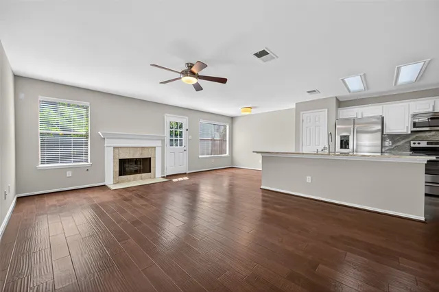 a view of an empty room with a kitchen and a fireplace