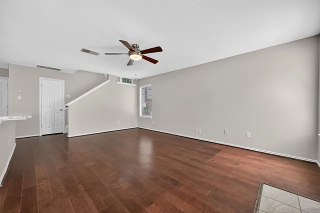 a view of a big room with wooden floor and windows in a room