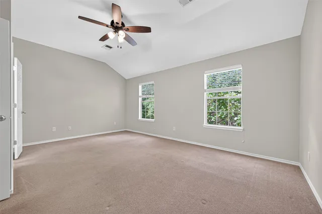 an empty room with a window and a fan