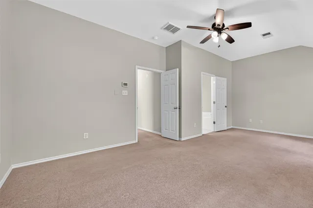 a view of an empty room with a ceiling fan
