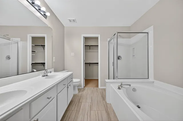 a spacious bathroom with a tub sink shower and mirror