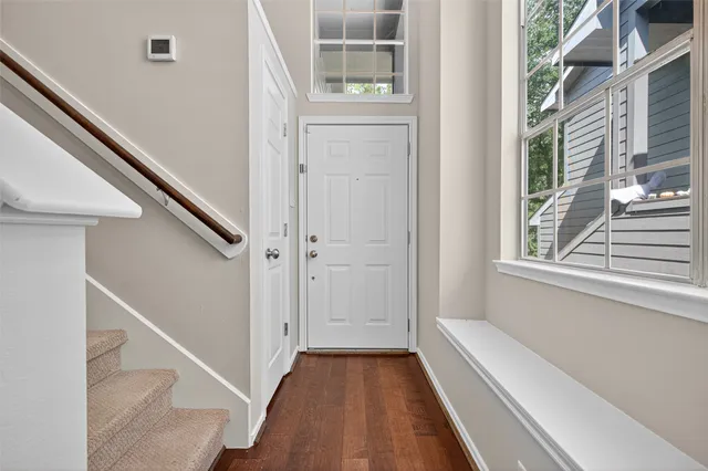 a view of a hallway with wooden floor and staircase