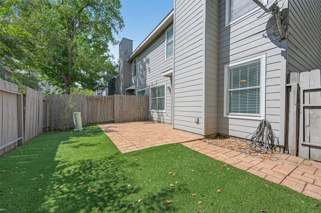 a view of a backyard with a small cabin and wooden fence