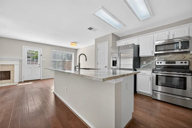 a kitchen with stainless steel appliances a stove top oven and a refrigerator