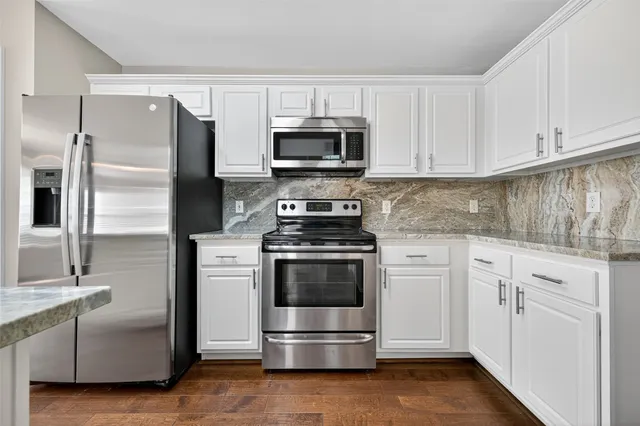 a kitchen with cabinets stainless steel appliances and a counter space