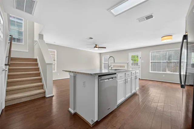 a kitchen with granite countertop a sink and a stove top oven