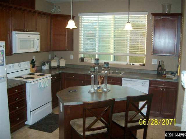 3094 Sterling Ridge Circle Sparks, NV 89431 - Photo 3 of 8 a kitchen with a table chairs sink and cabinets