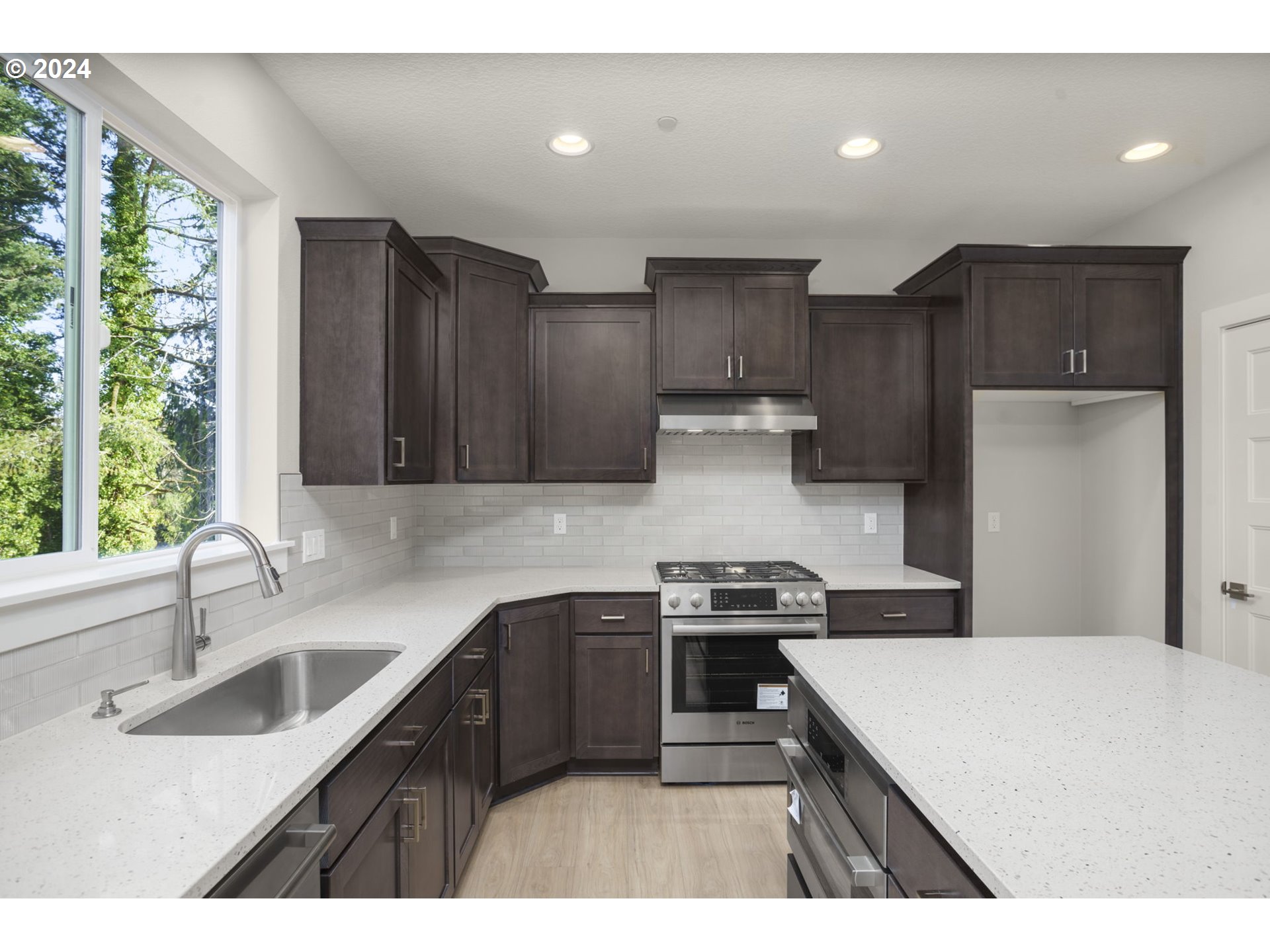 7233 Northeast Ridge Drive Hillsboro, OR 97124 - Photo 2 of 24 a kitchen with kitchen island a sink appliances cabinets and a large window