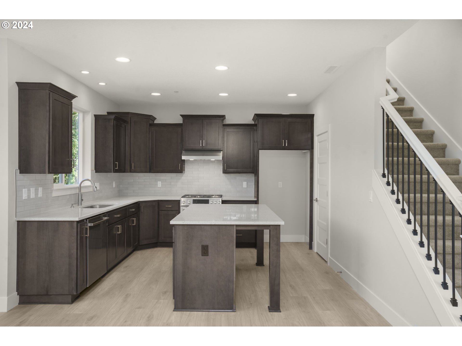 7233 Northeast Ridge Drive Hillsboro, OR 97124 - Photo 8 of 24 a kitchen with kitchen island a sink stainless steel appliances and cabinets