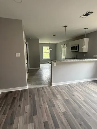 a view of a kitchen with wooden floor and a sink