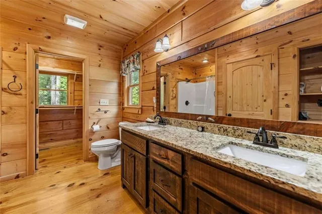 a bathroom with a granite countertop sink toilet and shower