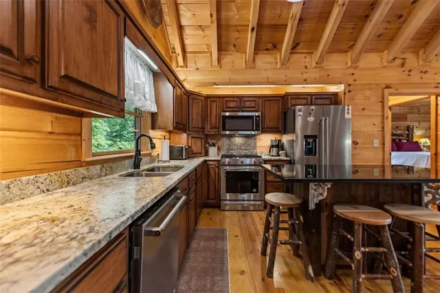 a kitchen with stainless steel appliances granite countertop a sink a stove and cabinets