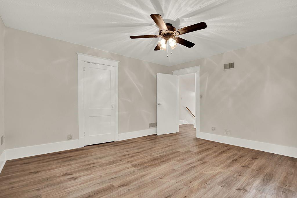 62 1st Street Irwin, PA 15642 - Photo 14 of 27 an empty room with wooden floor fan and windows