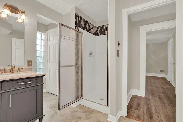 a bathroom with a shower sink and mirror