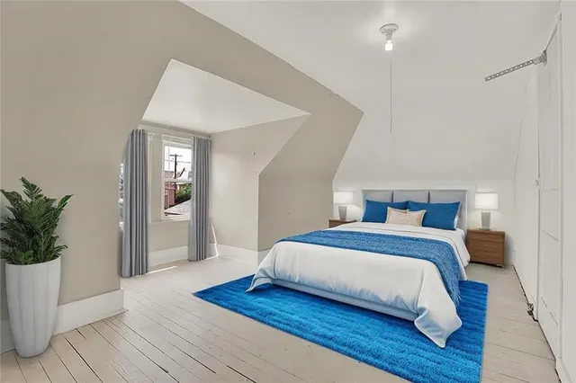 a bedroom with a large bed and a potted plant