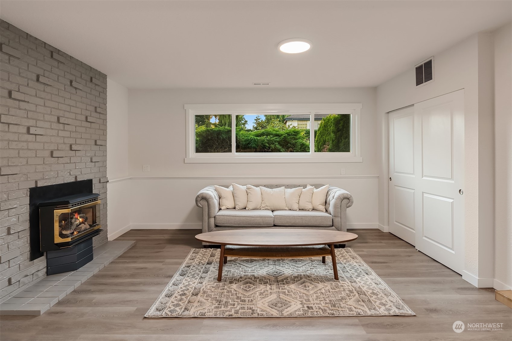 1005 Ave A Snohomish, WA 98290 - Photo 12 of 27 a living room with furniture a rug a fireplace and a large window