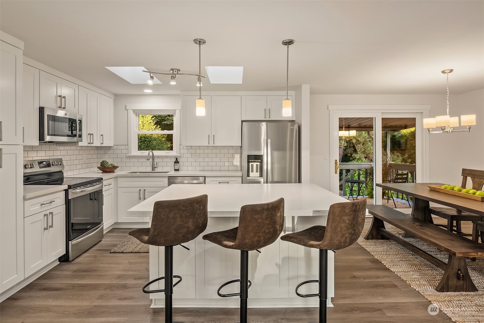 1005 Ave A Snohomish, WA 98290 - Photo 3 of 27 a kitchen with stainless steel appliances kitchen island granite countertop a refrigerator a stove a oven with white cabinets and wooden floor