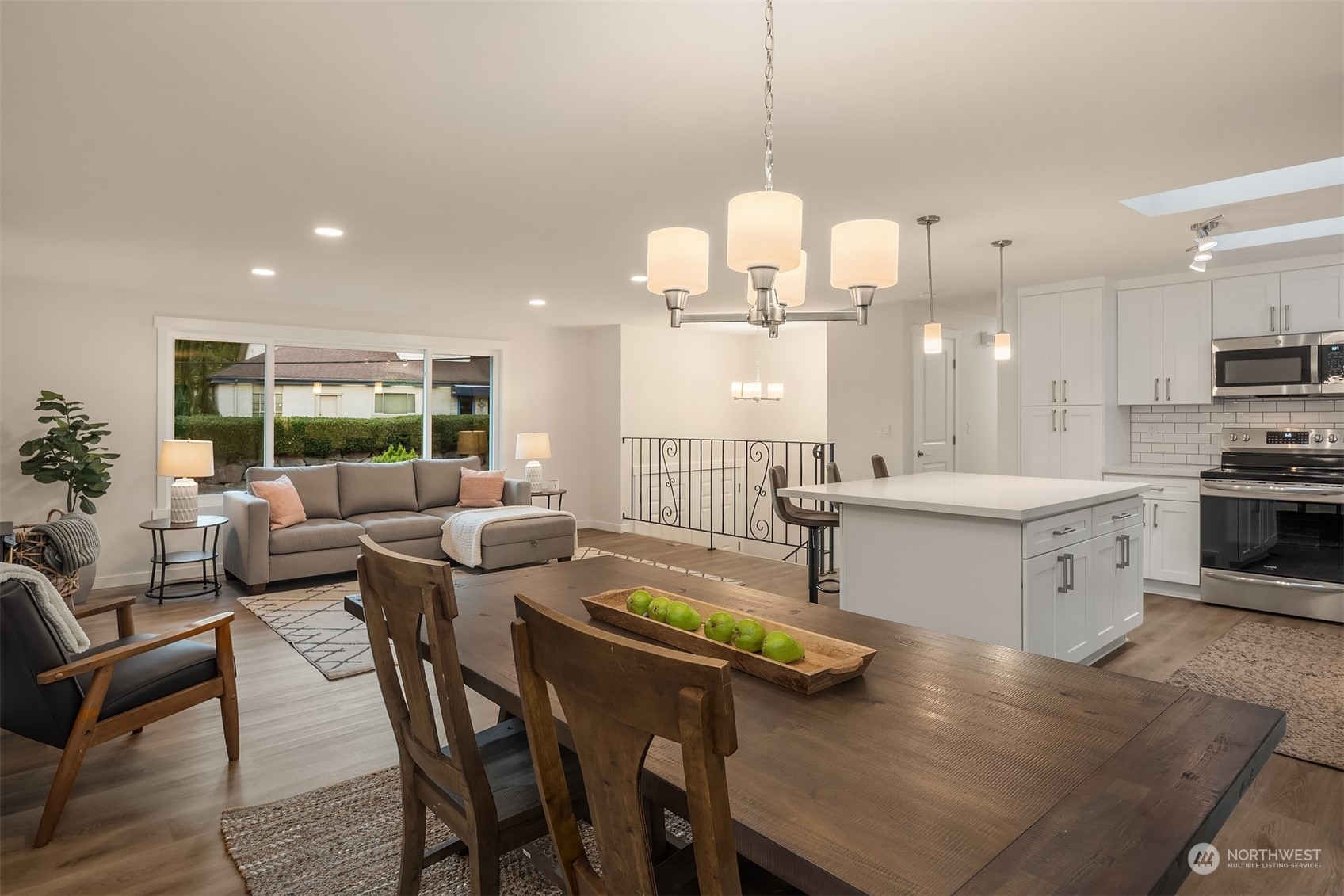 1005 Ave A Snohomish, WA 98290 - Photo 6 of 27 a kitchen with stainless steel appliances kitchen island granite countertop a stove a sink a dining table and chairs with wooden floor