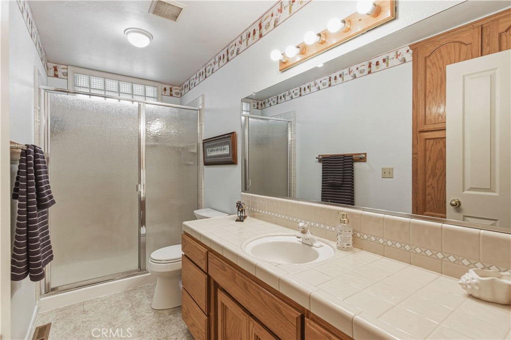 3856 North Gardner Avenue Merced, CA 95340 - Photo 38 of 59 a bathroom with a granite countertop sink a toilet and shower