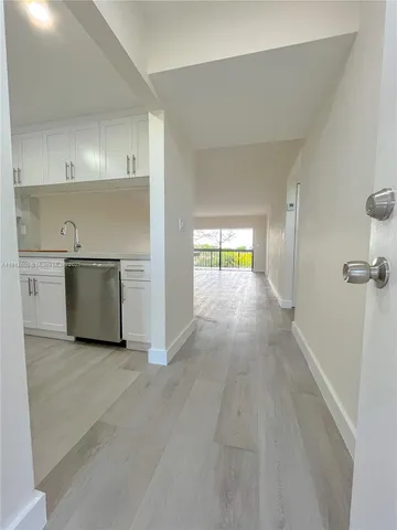 a kitchen with granite countertop a sink a stove top oven and wooden floors