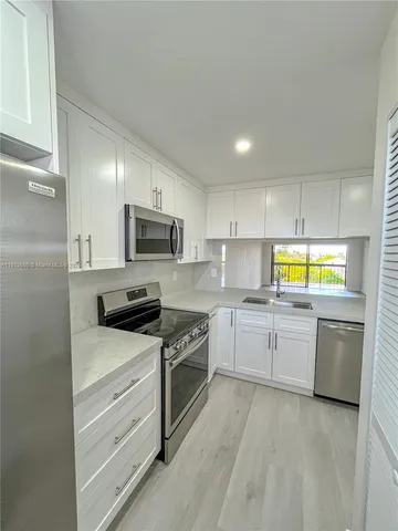 a kitchen with stainless steel appliances granite countertop a stove a microwave and a sink