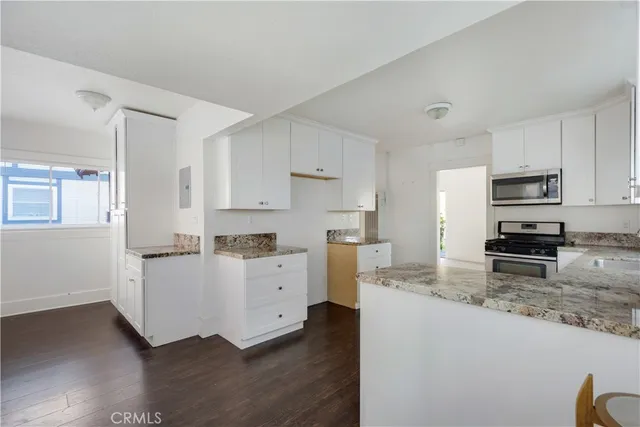 a kitchen with granite countertop a sink stove and refrigerator