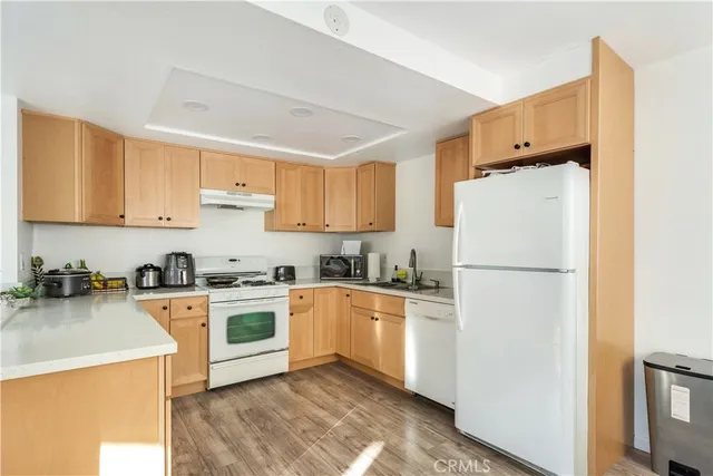 a kitchen with a refrigerator a stove a sink and cabinets