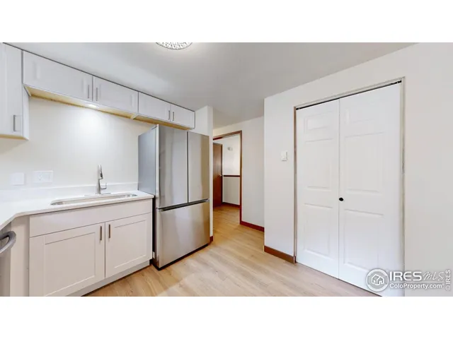 a open kitchen with a sink and refrigerator