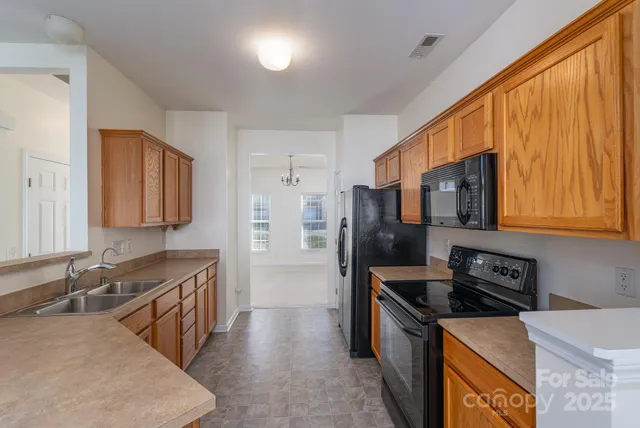 a kitchen that has a sink a stove and stainless steel appliances