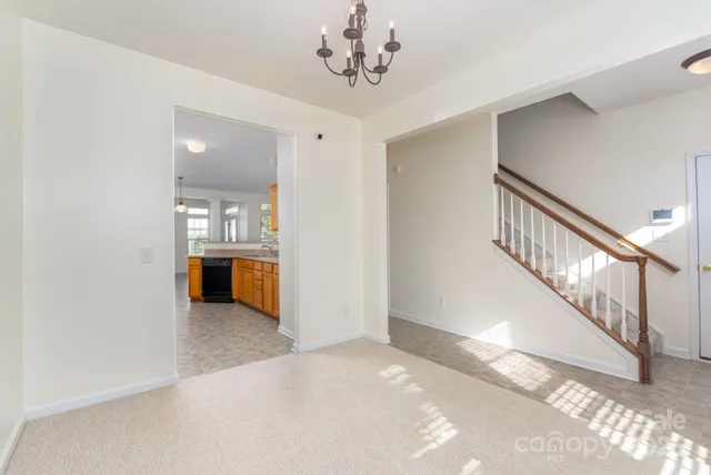 a view of a livingroom with wooden floor and a kitchen space