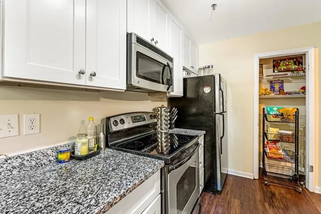 a kitchen with stainless steel appliances granite countertop a refrigerator sink and stove