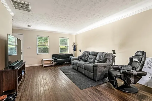 a living room with furniture a window and a flat screen tv