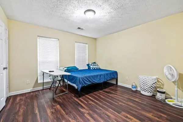 a spacious bedroom with a bed and a table in it