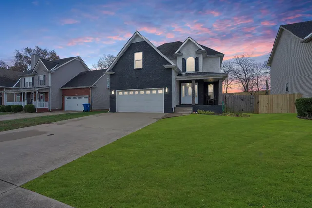a front view of a house with a garden and trees