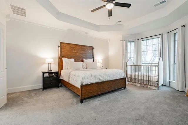 a bed sitting in a spacious bedroom next to a window