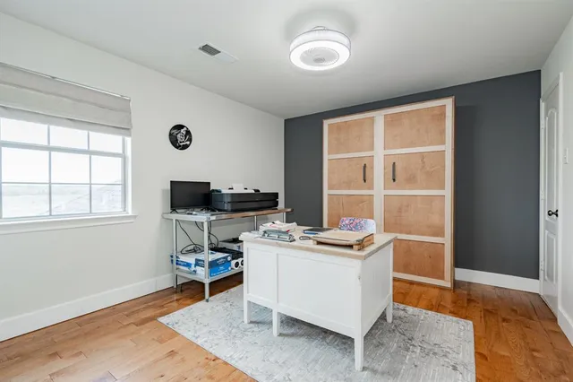 a view of a workspace with furniture and a window