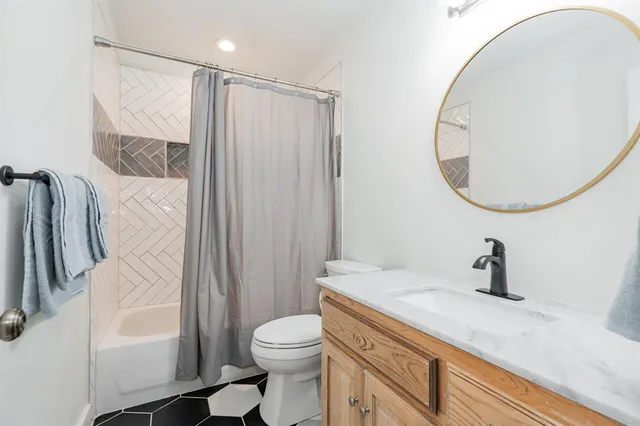 a bathroom with a sink a toilet and a mirror