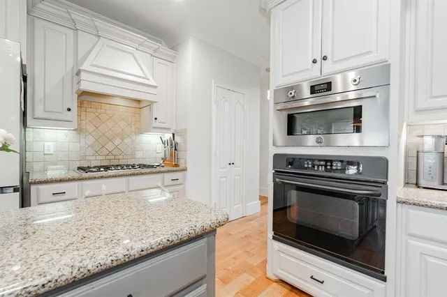 a kitchen with stove top oven and cabinets