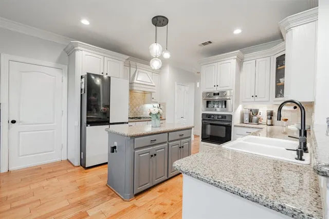 a kitchen with stainless steel appliances granite countertop a sink refrigerator and cabinets